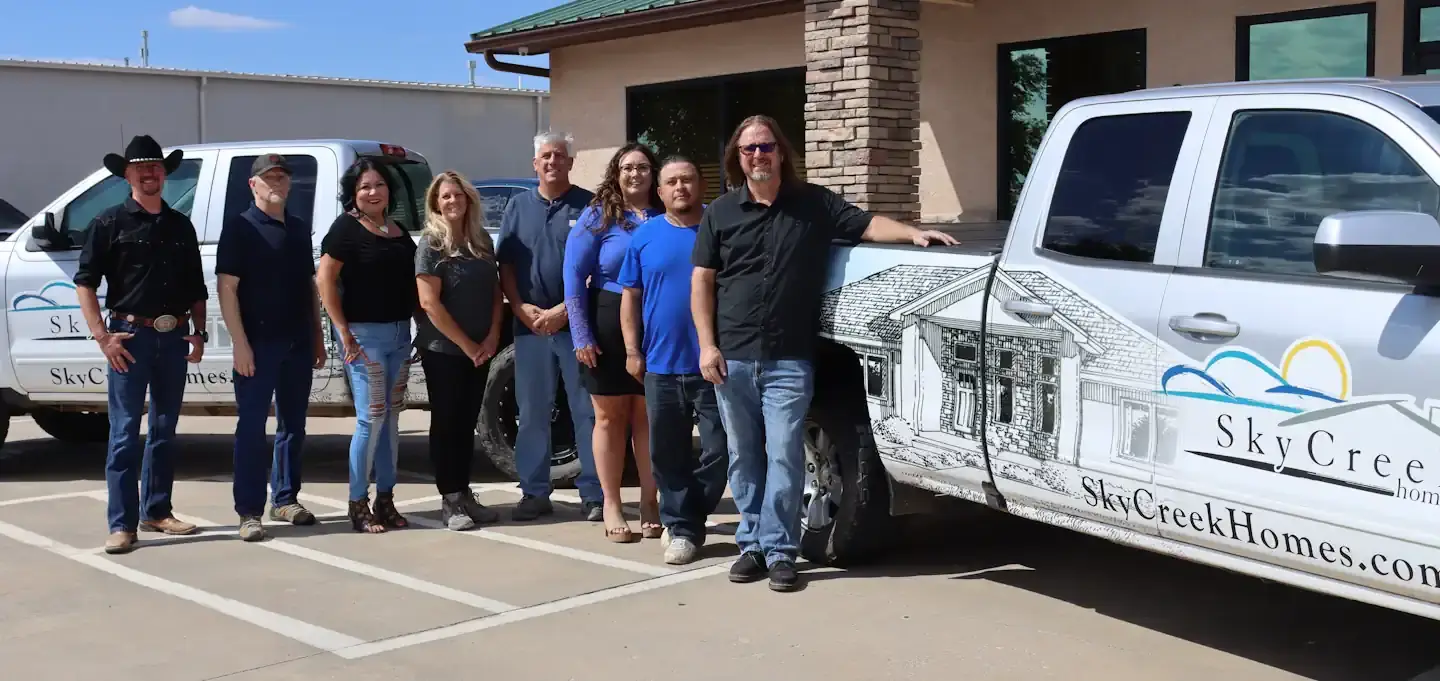 The Sky Creek Homes employees standing in front of the Sky Creek Home trucks.